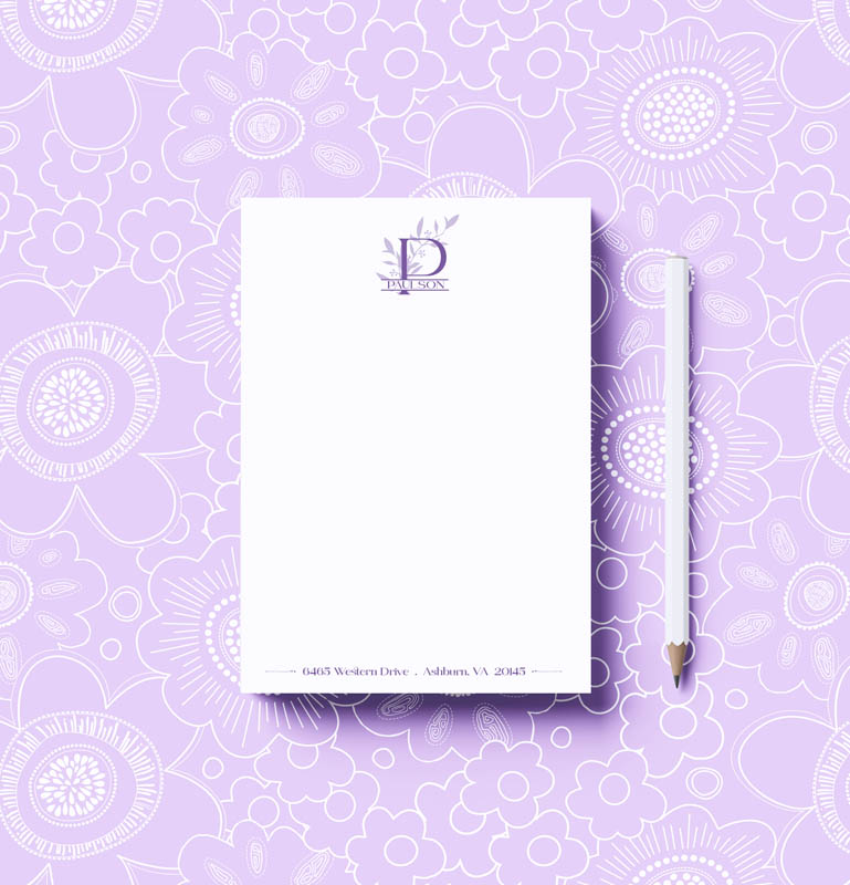 Notebook and pencil on a purple floral patterned background