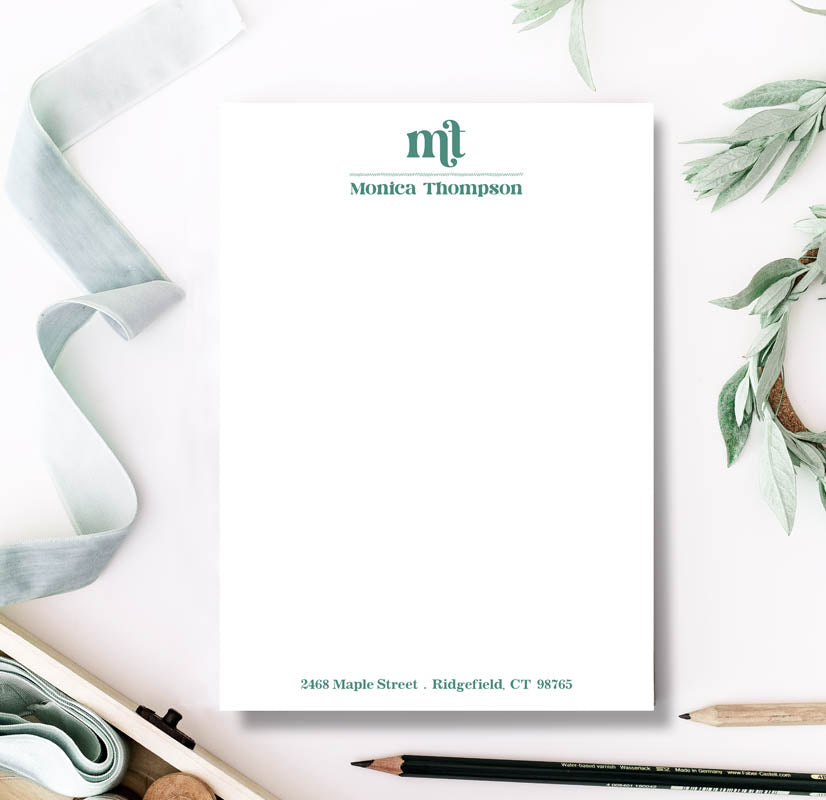 Personalized stationery set with a pen, paper, and decorative elements on a white background