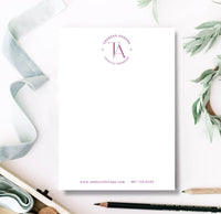 Notebook with a personalized design featuring a logo and text on a white background with greenery.