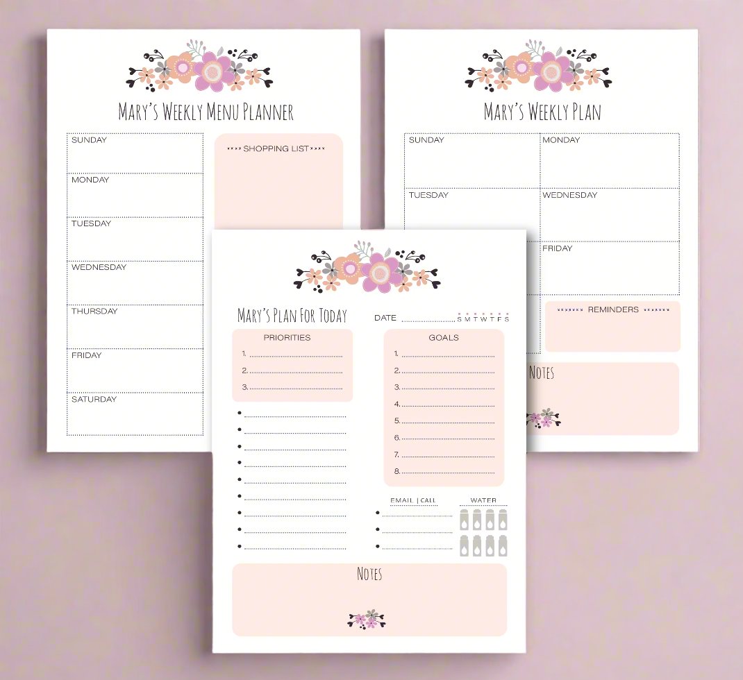 Three planner note pads laid out flat with floral designs on the cover, labeled for daily, weekly, and monthly planning.