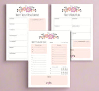 Three planner note pads laid out flat with floral designs on the cover, labeled for daily, weekly, and monthly planning.