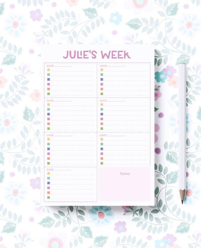 A notepad with a pink border and titled 'Julie's Week' on the cover, along with a pen and additional notepad visible on the side.